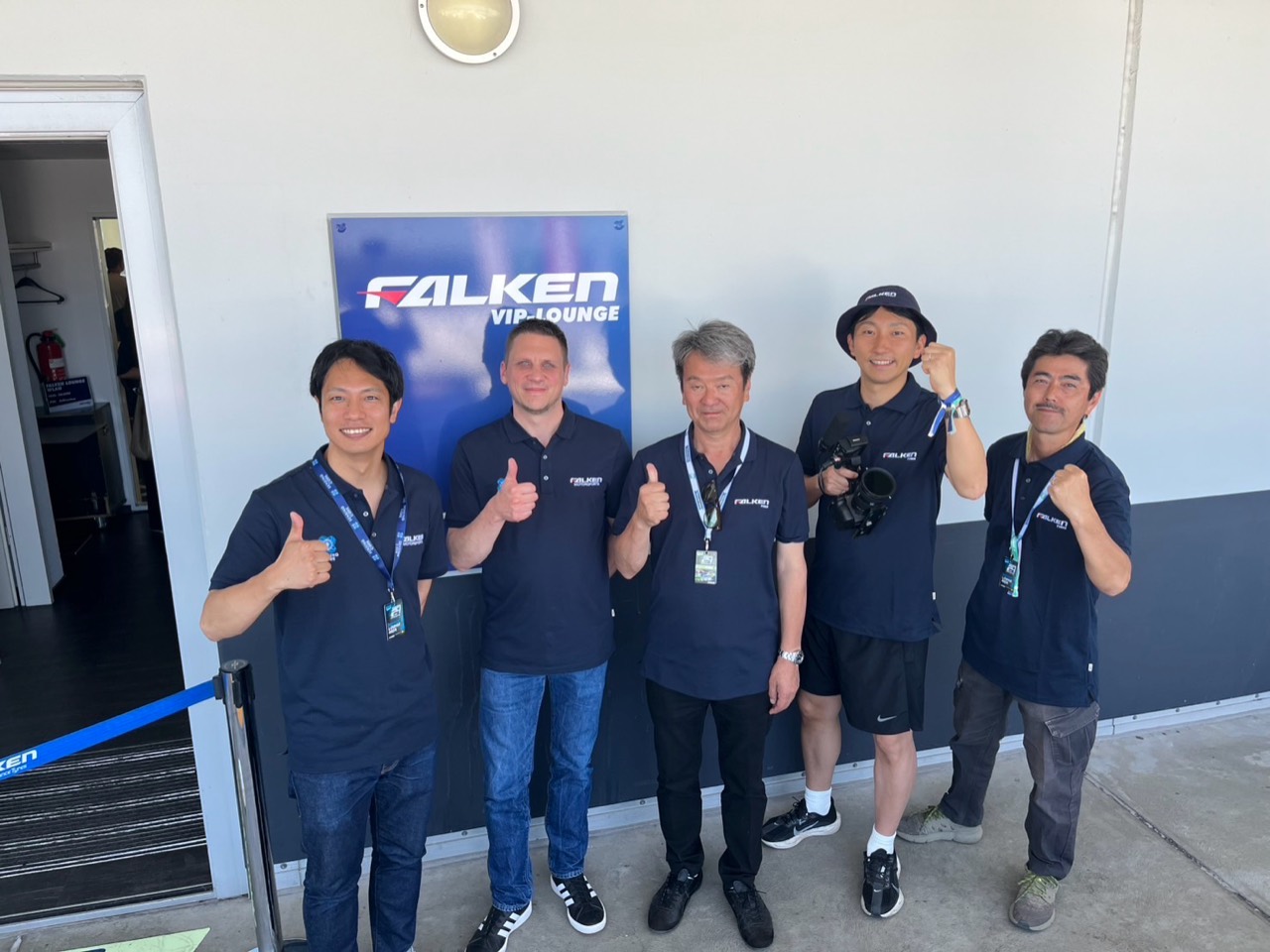 FALKENのサインを背景にした現場での集合写真