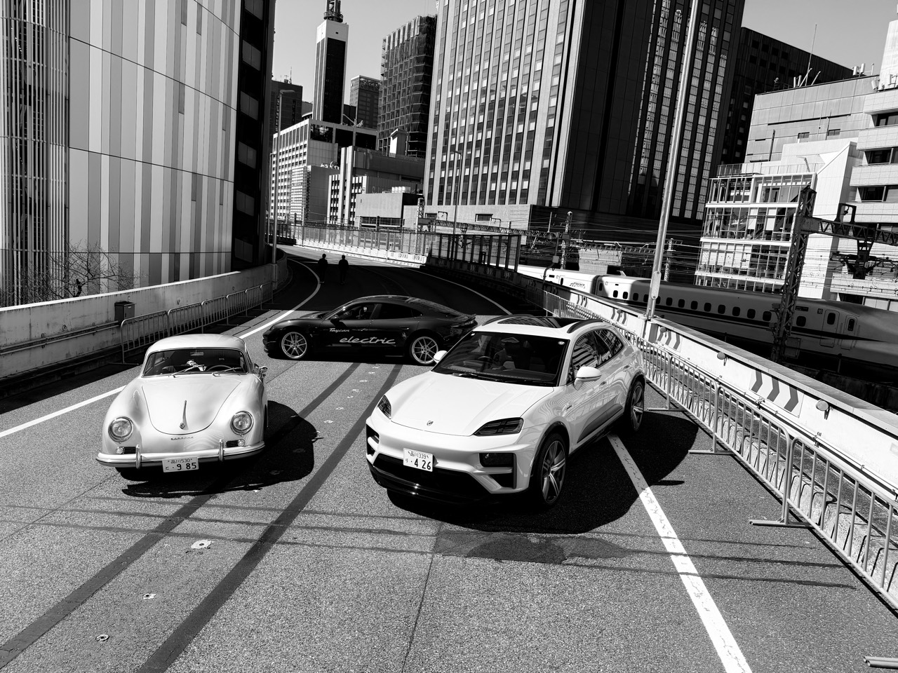 都市の景観を背景に並ぶ車両