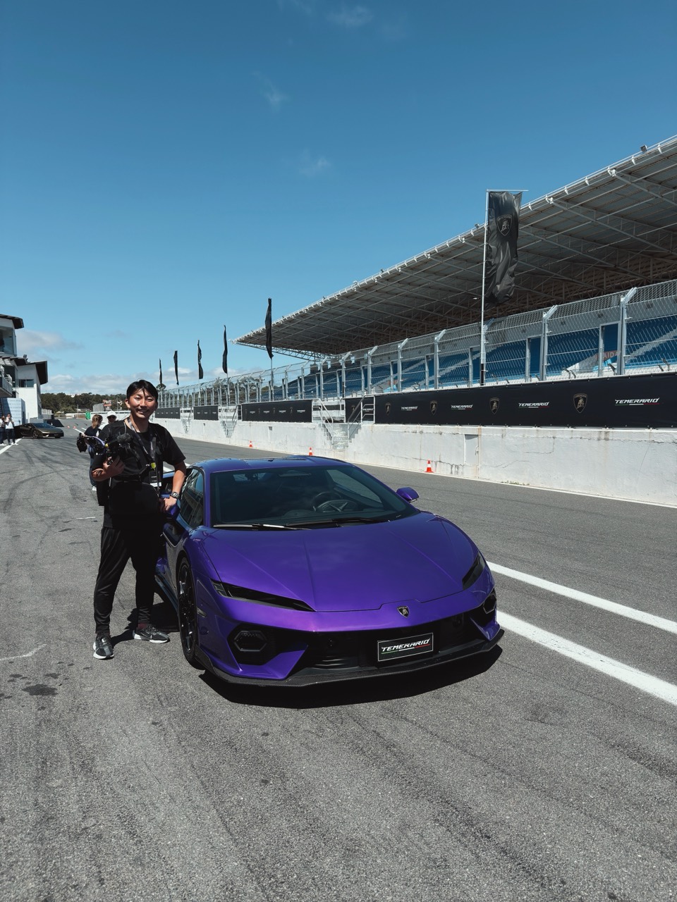 サーキットでの車両と撮影スタッフ
