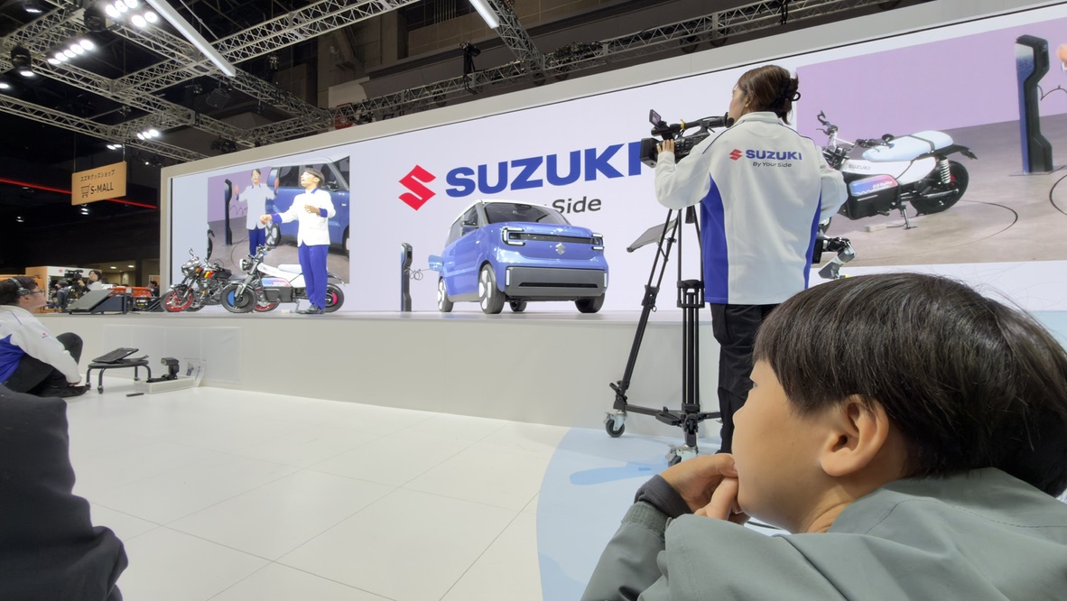 自動車の展示ステージを撮影するカメラマン