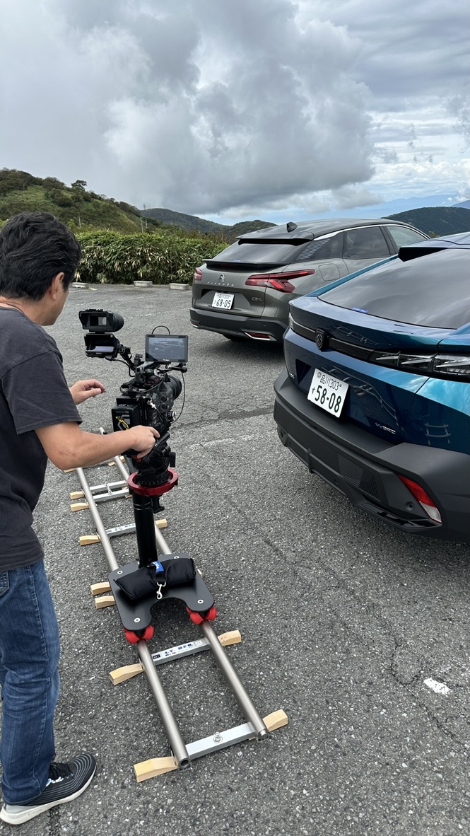 レールに載せたカメラで車両を撮影するスタッフ