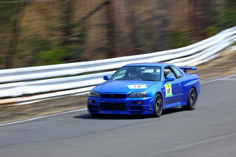 サーキットを走行する青いスポーツカー