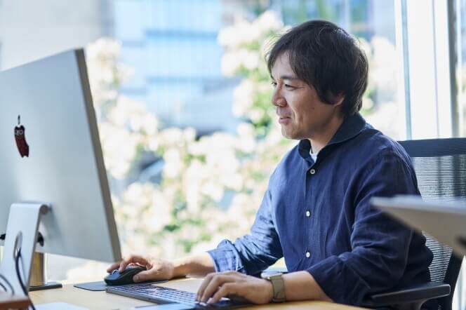 大きな画面で作業する男性