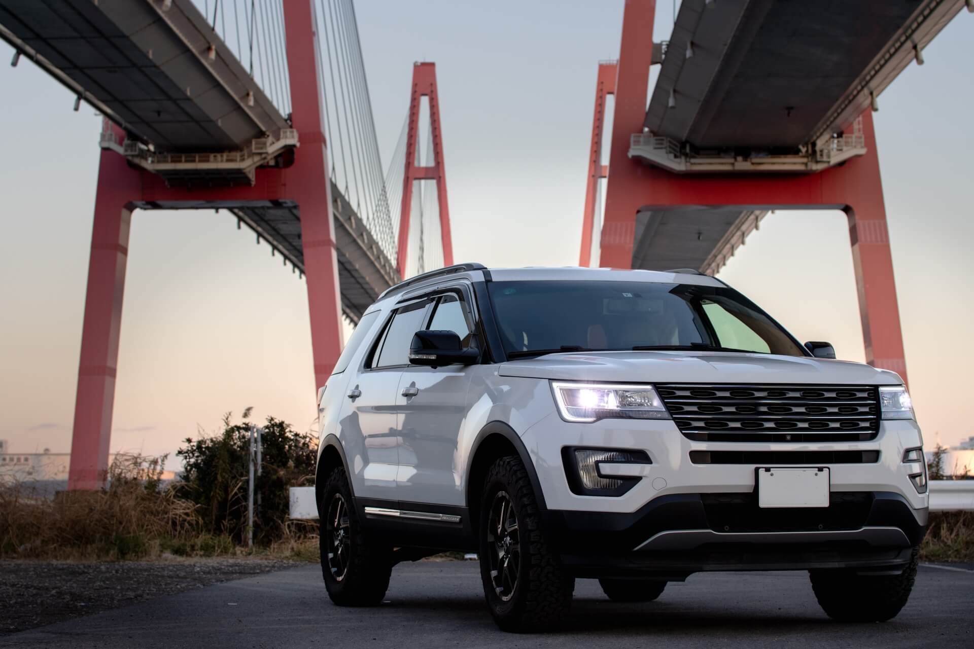 夕暮れ時に橋の下を通るSUV